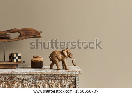 Stylish composition at moroccan interior with wooden shlef, cube, design elephant figure and decoration in modern home decor. Details. Template. Copy space.