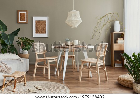 Stylish interior of dining room with family table, rattan chairs, pendatn lamp, plant, tableware, carpet, decoration and elegant accessories. Template. 