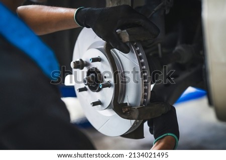 Auto mechanic installing disc brake caliper bracket. Foto d'archivio © 