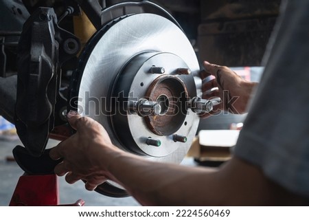 Auto mechanic installing car front brake rotors.	 Foto d'archivio © 