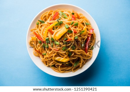Schezwan Noodles or vegetable Hakka Noodles or chow mein is a popular Indo-Chinese recipes, served in a bowl or plate with wooden chopsticks. selective focus Foto d'archivio © 