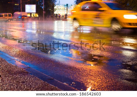 Night rain in the city with rain drops and taxi