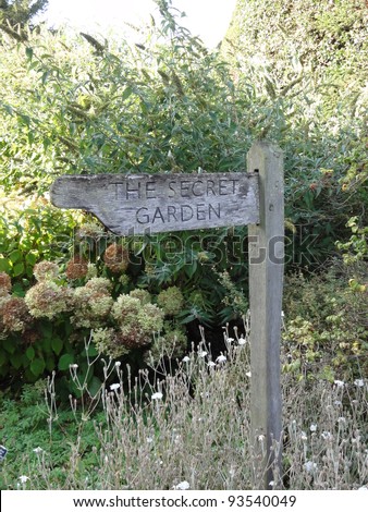 Photo of a sign in a garden with the text secret garden
