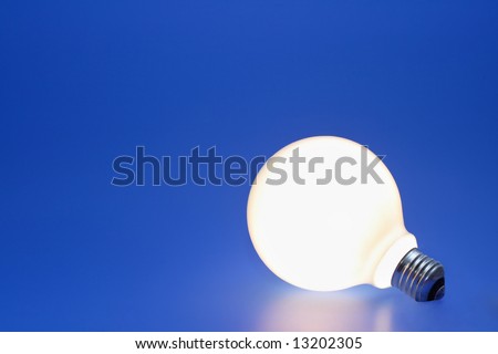 A lit up light bulb on a blue background.