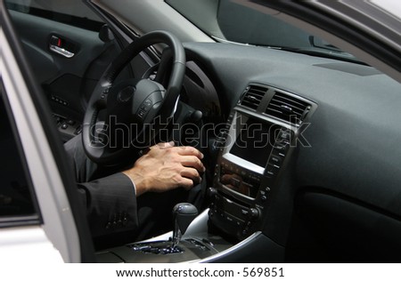 man\'s hand in new car interior, man wearing a business suit