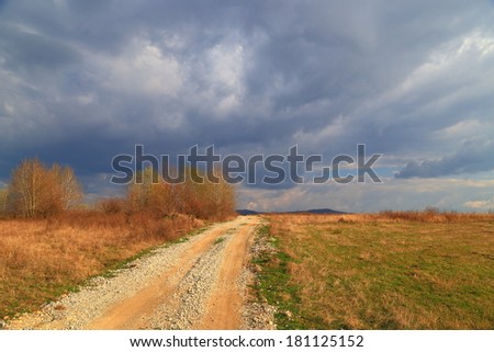 Country side road under gloomy sky