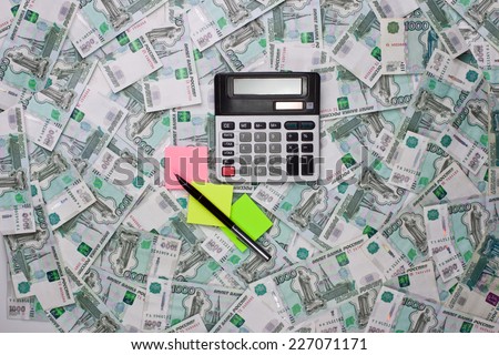 Calculators and colored stickers on the background of the Russian money