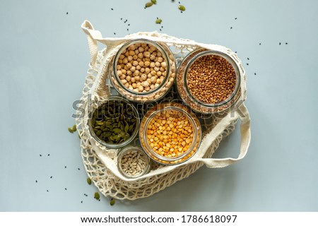 Organic bio bulk products in zero waste shop. Foods storage in kitchen at low waste lifestyle. Cereals and grains in glass jars on table. Eco friendly shopping in plastic free grocery store.