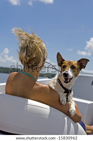 Woman and jack russel enjoying a fast boat ride.
