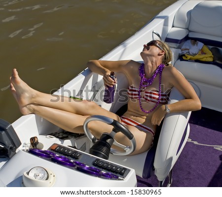 Young attractive girl laughing and relaxing on a speed boat.
