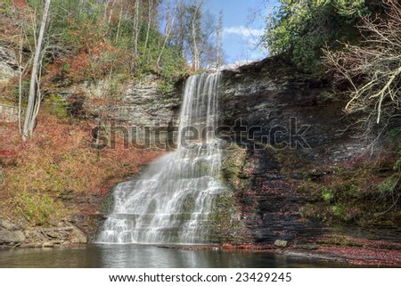 Beautiful tall waterfall falling into a lagoon during autumn.