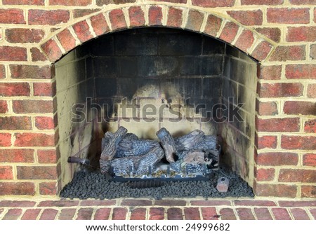Close up of gas fireplace surrounded with brick.