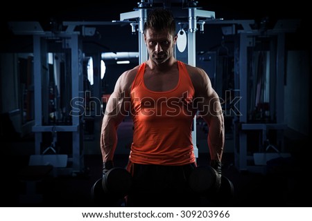very power athletic guy standing with barbell, workout in the gym