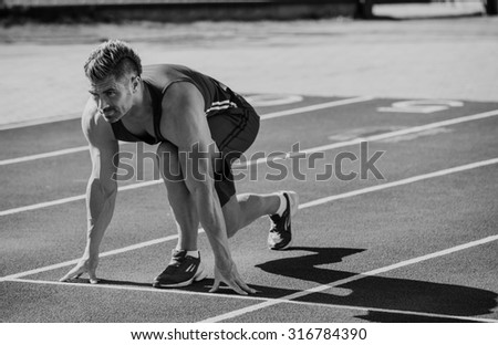 Athletic man starting evening jogging in sun rays
