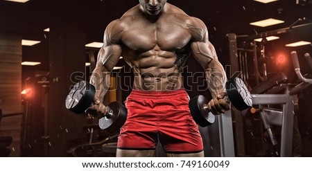 Handsome man with big muscles, posing at the camera in the gym Foto stock © 