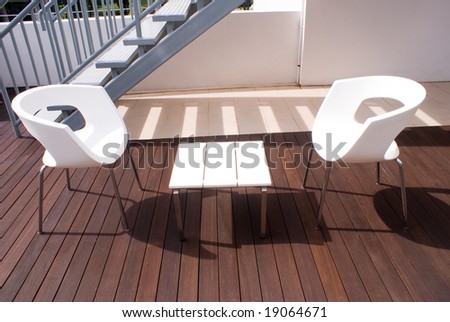Open bar on wooden floor with white chairs