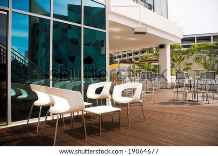 Open bar on wooden floor with white chairs