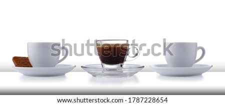 A row of 3 glass and white expresso cups and saucers full of smooth expresso coffee, on a white style bar or table top with a white background ストックフォト © 