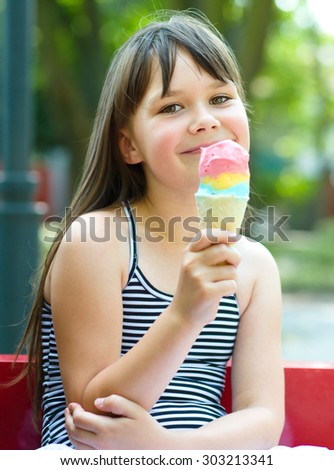 Cute happy girl is eating ice-cream