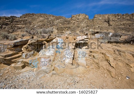 Graffiti on desert mountains (Eastern Washington) under blue sky