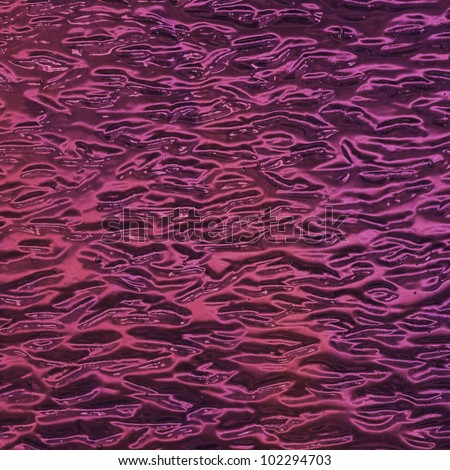 Image of a pink colored stained glass window with a wave texture, square format