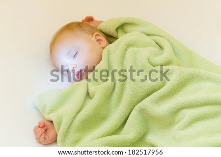 Carefree sleeping little baby on a bed, magic dreaming