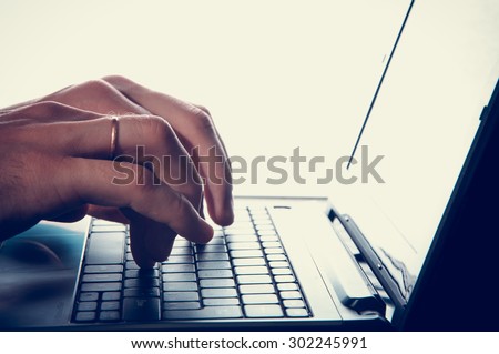 Man\'s hands typing on laptop keyboard. vintage