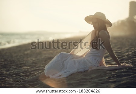 Girl relaxing on the sand on the beach looking at the horizon