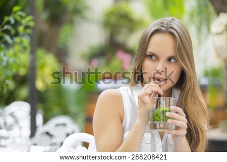 Girl drinking a cocktail in the garden