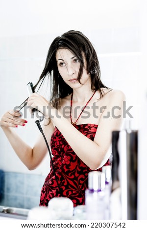 Natural Beauty straightening her long Hair. Woman doing morning routine in bathroom.