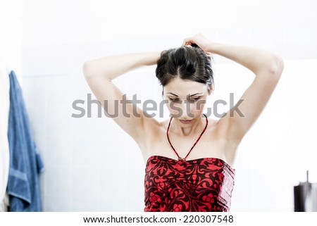 Natural Beauty styling her Hair. Woman doing morning routine in bathroom.