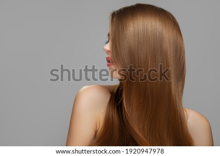 Woman's clean styled hair. Half of the face is covered with brunette hair