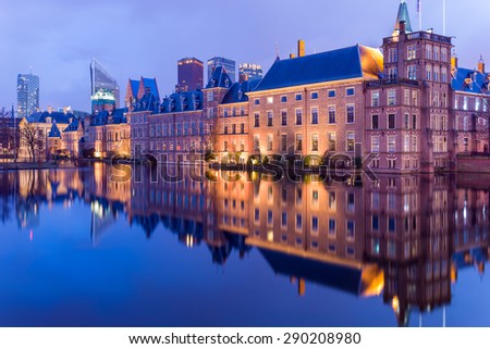 The Hague (Den Haag) skyline panorama with Binnenhof palace (Dutch Parliament) and modern skyscrapers reflected in the Hofvijver canal at twilight, The Netherlands.