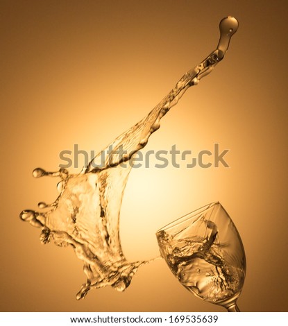 White wine splash on gold background