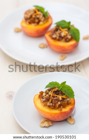 Peach dessert with date and walnut on white plate