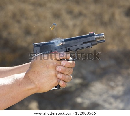 Semi automatic handgun that has ejected a case and is feeding another