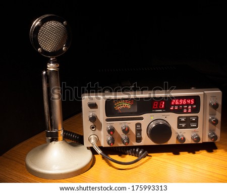 Two way radio and microphone that are on a dark desk