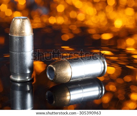 Handgun ammunition with a hollow point bullet and an orange background