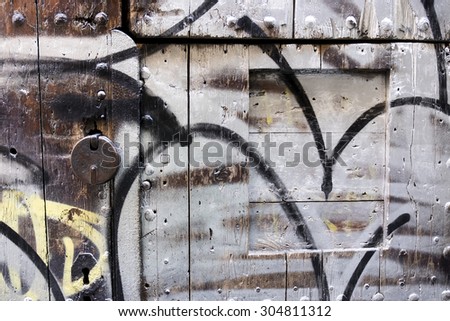 Graffiti covered door with metal padlock