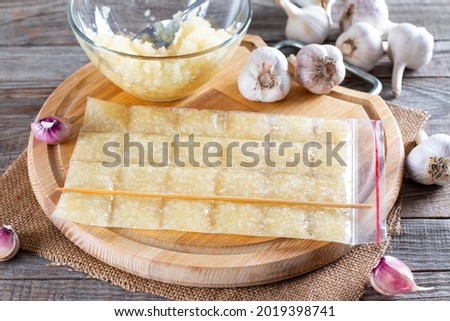 Frozen garlic. Frozen garlic puree on wooden table. Frozen food Concept