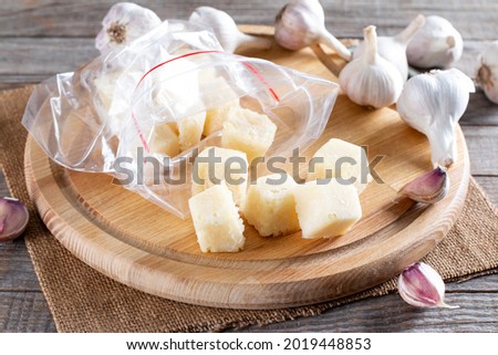 Frozen garlic. Frozen garlic in ice cube on wooden table. Frozen food Concept
