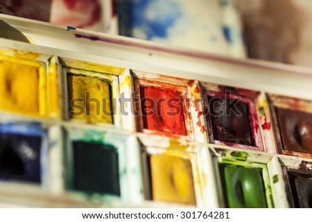 Used watercolour paint palette showing bright, well used paints