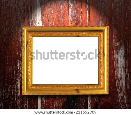 gold picture frame with light and shadow on wood background