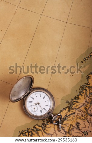 Old silver pocket watch on ancient map