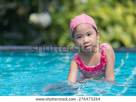 Little cute Asian girl on bikini suit in pool