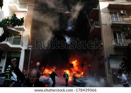 ATHENS-GREECE - APRIL 26. Fire fighters tries to extinguish burning cars following an arson attack by anarchists at a central police station in Athens, April 26, 2007.