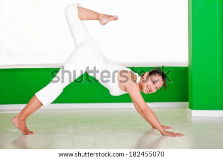 Pretty Chinese woman performing the yoga exercise indoor