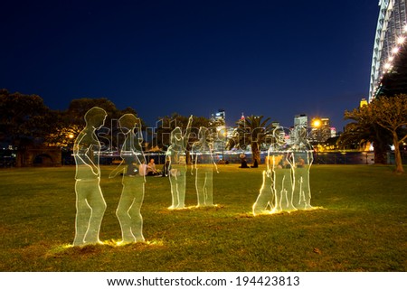 SYDNEY,AUSTRALIA - May 23,2014: Young adults enjoy an exhibit next to the Harbour Bridge on the first night of Vivid 2014. Vivid is a major annual festival of projections and light installations.