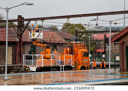 SYDNEY,AUSTRALIA - SEPTEMBER 7, 2014: A railway maintenance gang repairs overhead lines at Central Station. RailCorp is the custodian of railway property, infrastructure and trains in New South Wales.