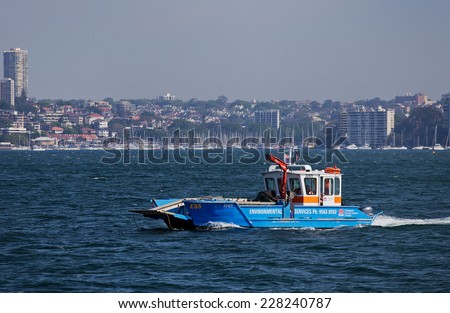 SYDNEY, AUSTRALIA - OCTOBER 24,2014: A state government waste disposal vessel crosses the harbour. The crane and surface-skimming equipment allows it to handle floating litter, waste and oil spills.